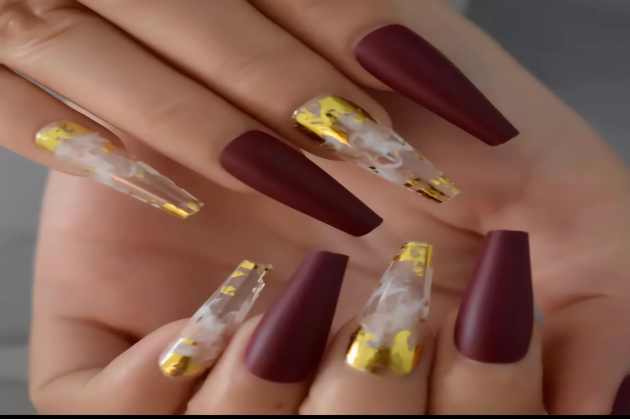 uñas largas color rojo vino, transparente y dorado